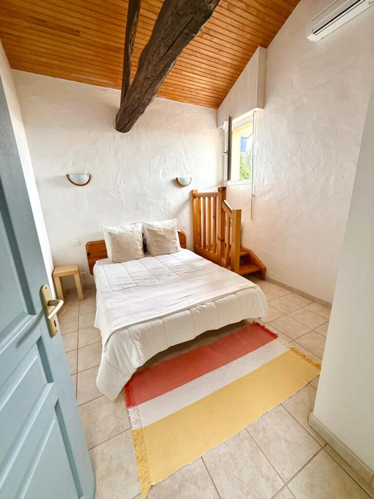 Chambre avec lit double et poutre apparente du gîte Le Chail (Landes 40)