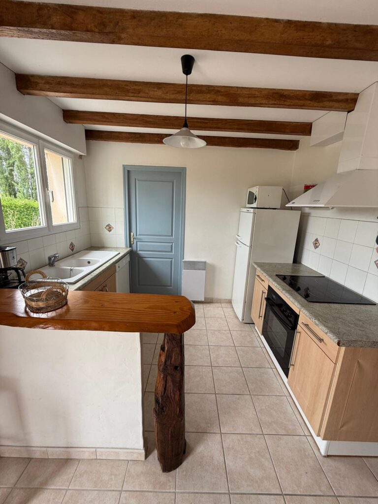 Cuisine équipée avec poutres apparentes du gîte Le Chail dans les Landes