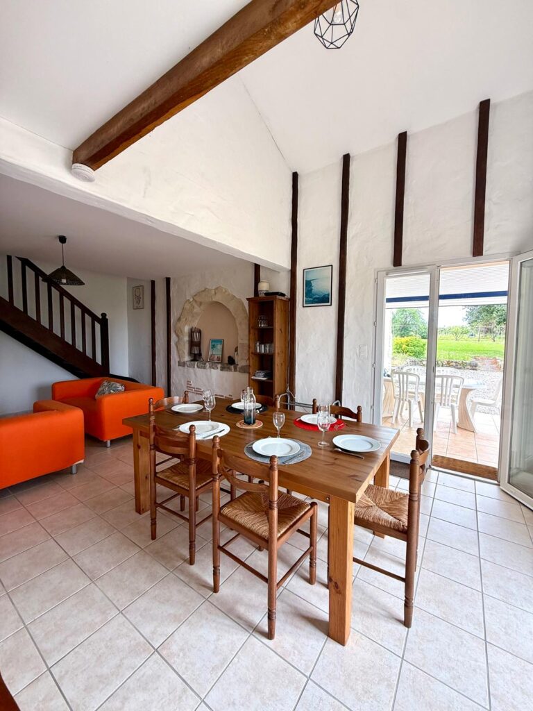 Salle à manger sous charpente avec niche en pierre du gîte Le Chail à Peyrehorade