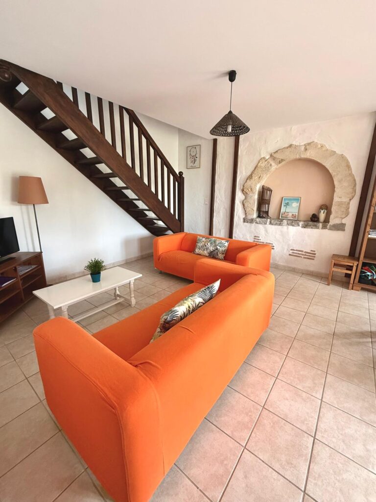 Salon avec canapés et niche en pierre d'origine - gîte Le Chail à Peyrehorade