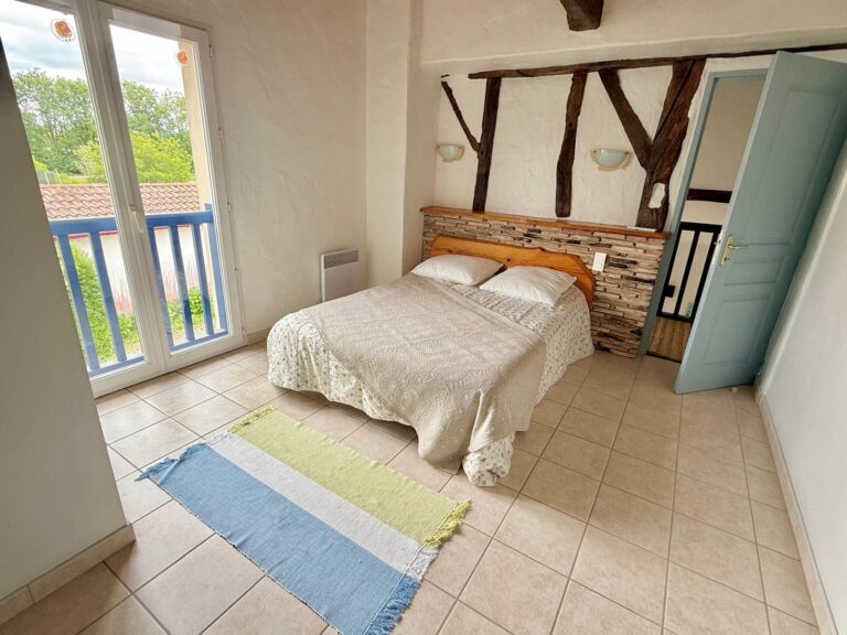Chambre lumineuse avec colombages et accès balcon - gîte Le Sau Sud-Ouest