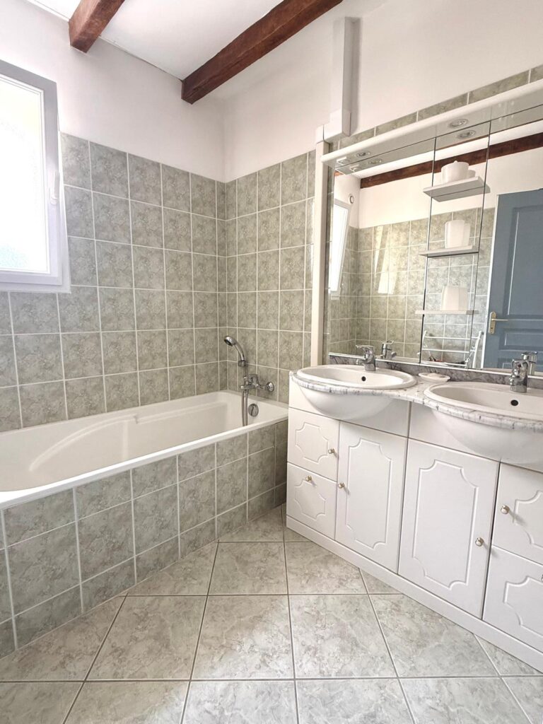 Salle de bain avec baignoire et double vasque du gîte Le Sau à Peyrehorade